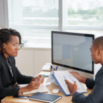 Female entrepreneur listening to report of financial manager